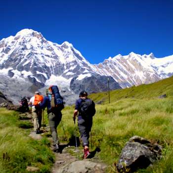 Trekkers standing at Annapurna Base Camp with the the grand Annapurna Massif before them